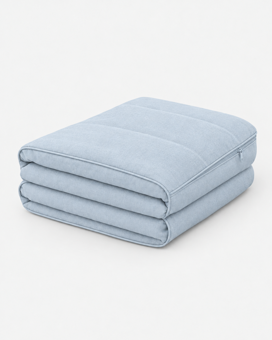A washable dog bed cover in pale powder blue, folded into a neat stack on a plain light grey background.