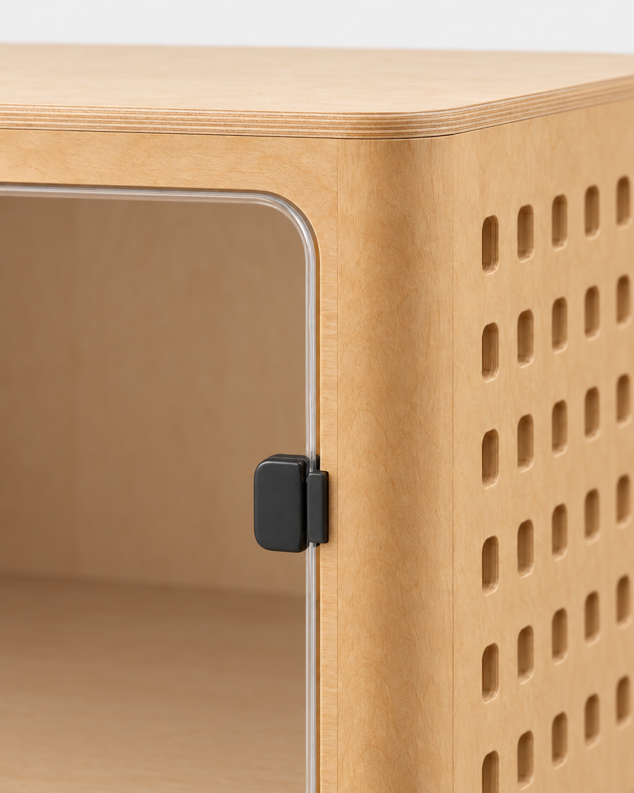 Close-up of the crate's front corner showing the small black latch on the clear acrylic door, the curved laminated plywood edge and the rounded-square airflow cut-outs.