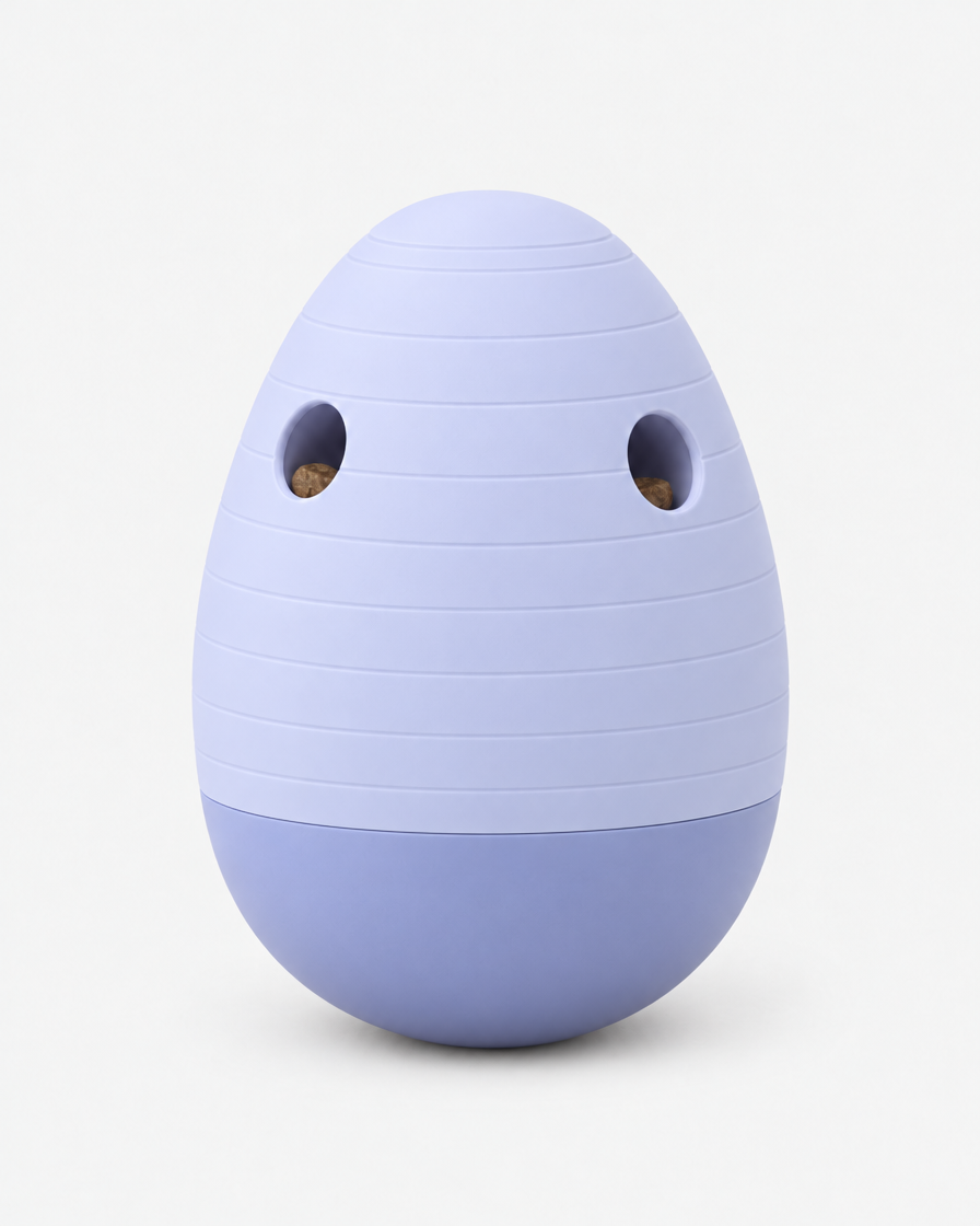 A pale periwinkle lavender egg-shaped puzzle feeder with horizontal grooves and two treat openings, standing on a light grey background.