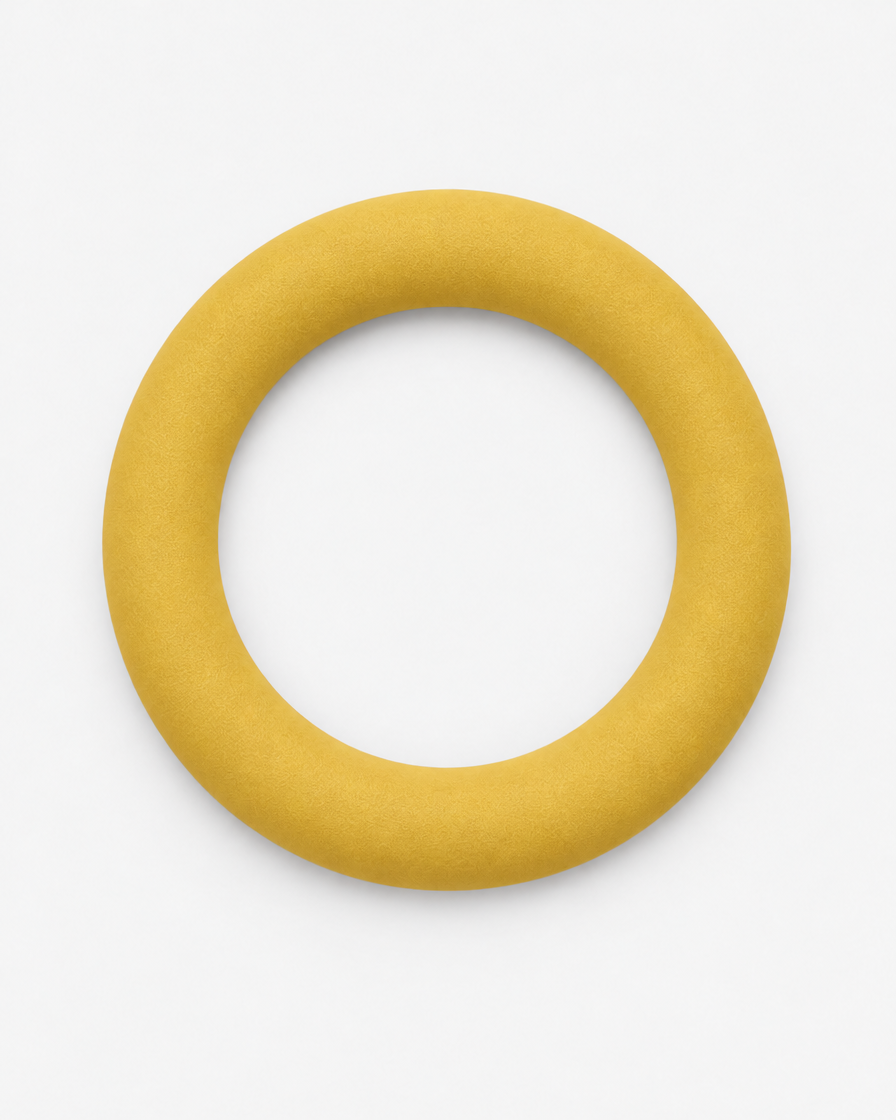 A soft golden yellow flying ring dog toy seen from above on a light grey background.
