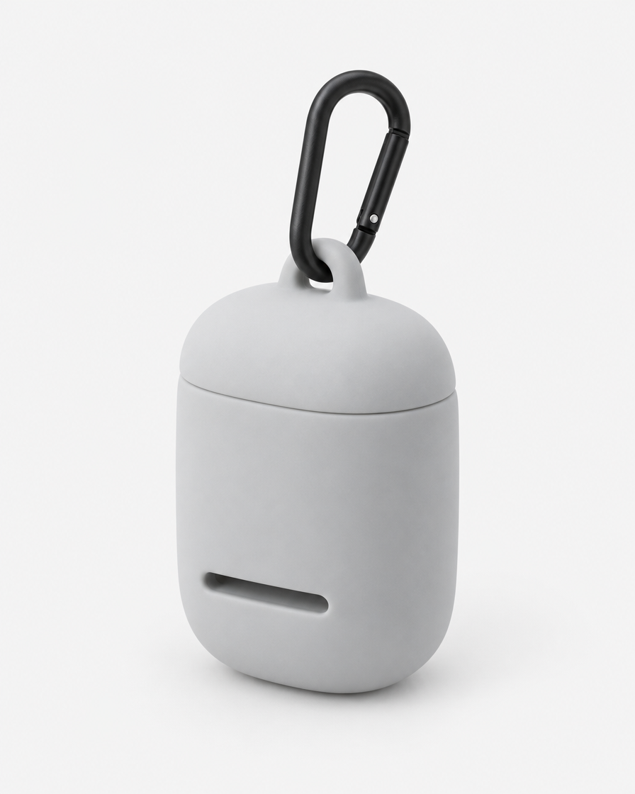 A small rounded silicone waste-bag pouch in very light cool grey with a magnetic lid, a front dispensing slot and a matte black carabiner, on a plain light grey background.