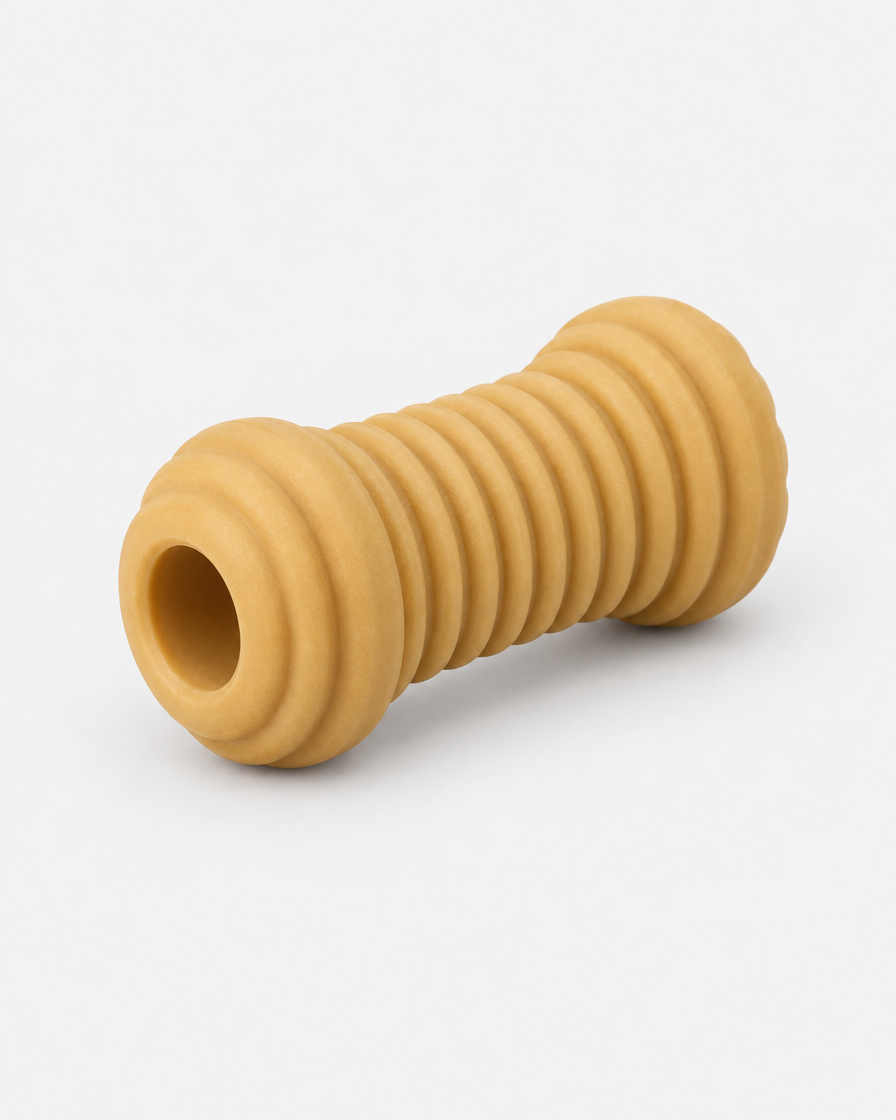 A ridged natural-rubber chew toy shaped like a short bone barrel with a hollow core, photographed on a light grey background.