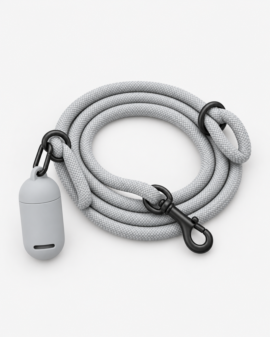 Three-quarter studio view of a light grey rope leash lying in a loose coil with a small grey silicone pouch clipped to its ring.